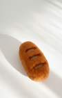 Needle-felted baguette magnet made from natural wool with scored surface detail