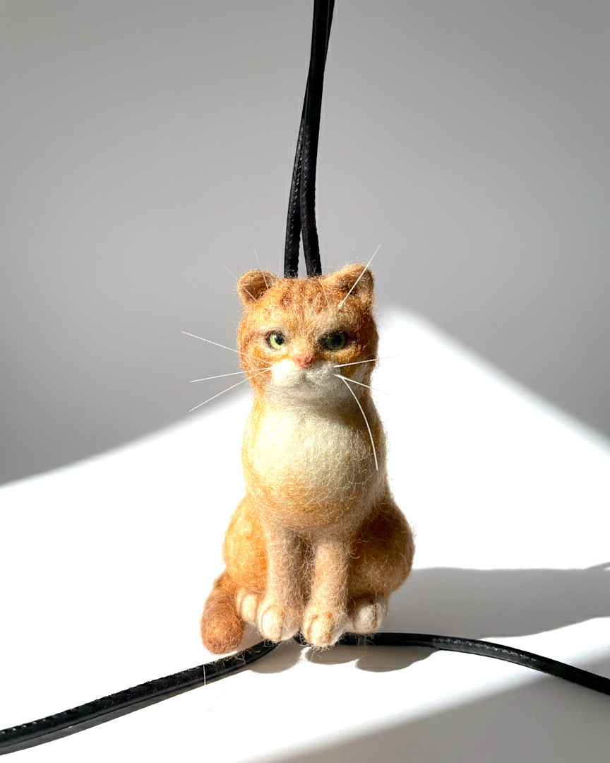 Handmade realistic ginger wool cat sculpture charm in sitting pose, detailed close look, needle-felted with lifelike details. 