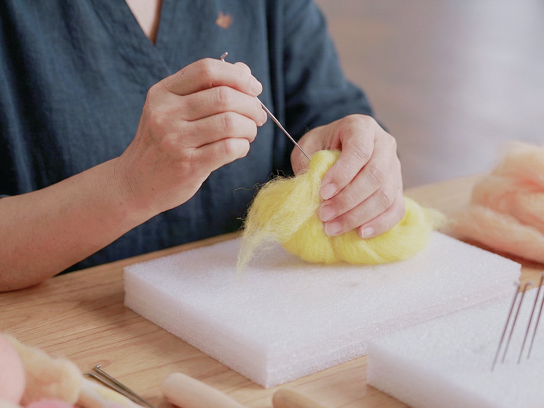 Needle-felted wool charm design process in partner studio.