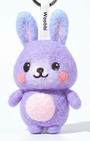 Front view of a handmade Woobbi bunny keychain, crafted from purple bubbly wool felt. It has small yellow ears, rosy pink cheeks, and a smiling face with black eyes and nose. A small tag with the brand name 'Woobbi' is attached to the top. It is set against a plain white background.