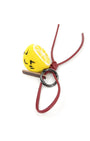Studio shot of handcrafted wool lemon keychain featuring a red leather loop, black metal hardware, and a cute winking face.