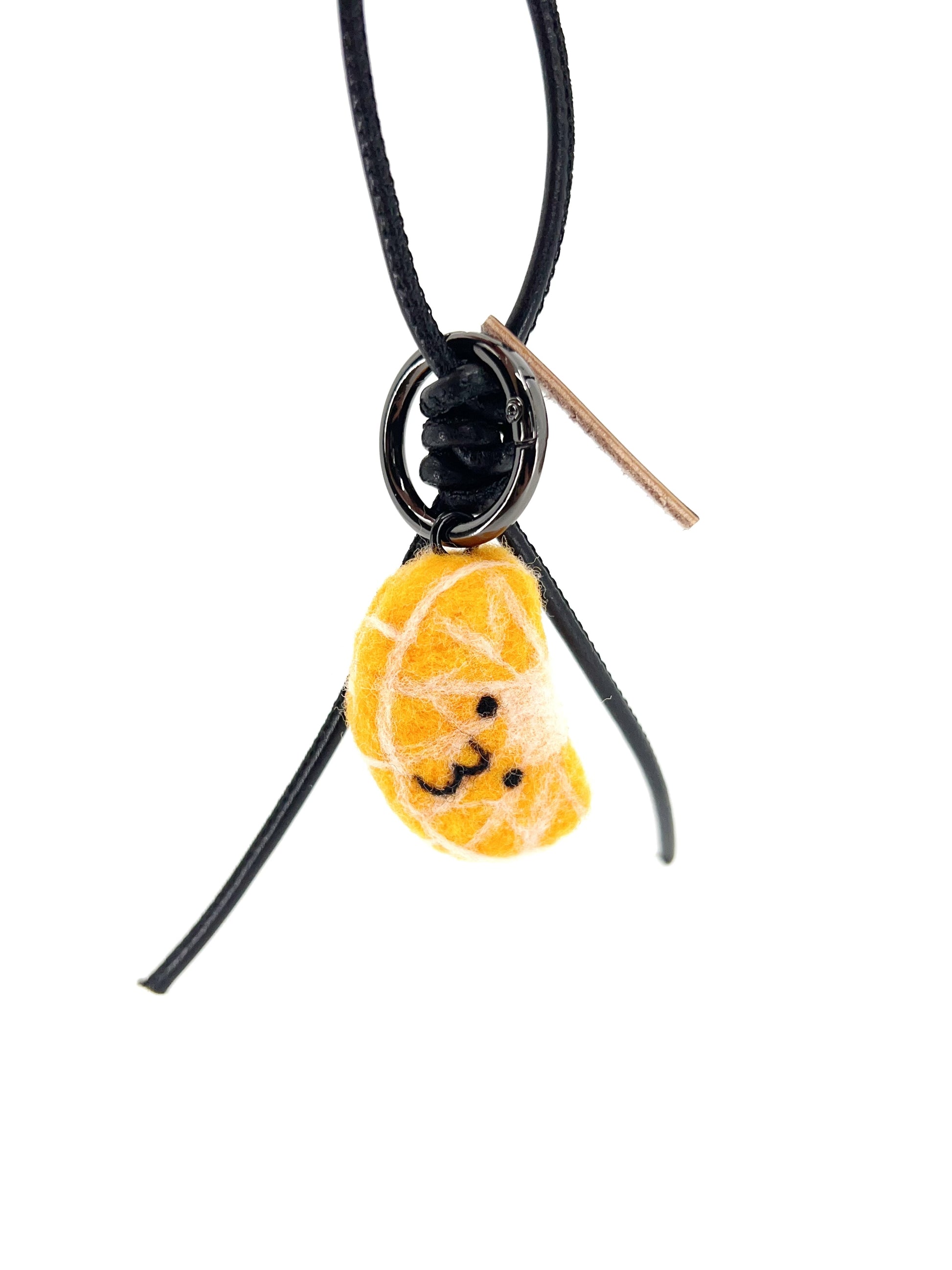 Hanging view of handcrafted wool citrus keychain featuring a black leather cord, black metal hardware, and a soft orange fruit design.