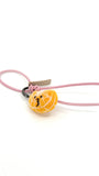 Studio product shot of cute needle-felted mandarin orange slice bag charm with pink leather strap and embroidered smiley face, isolated on white.