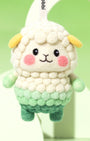 Macro detail of needle-felted sheep face showing the unique bubbly wool texture, rosy pink cheeks, and hand-stitched smile.