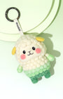High-angle view of needle-felted sheep bag charm featuring a white 'popcorn' texture fleece fading into a green gradient body, with cute yellow ears.