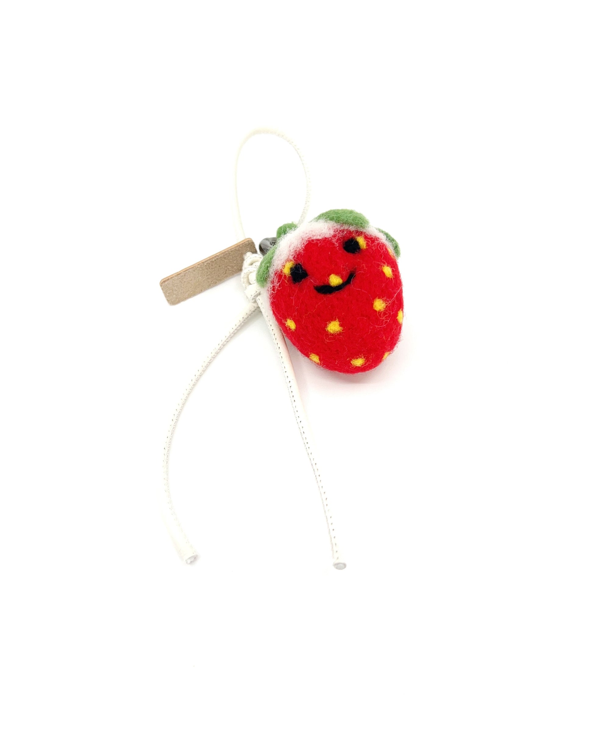 Front view of cute red strawberry bag accessory with white leather cord, highlighting the handmade Merino wool texture.