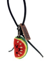 Studio product shot of needle-felted watermelon slice bag charm featuring a black leather cord and brown Woobbi brand tag, isolated on white background.