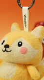 Macro detail of needle-felted fox face showing premium Merino wool texture, rosy pink cheeks, and hand-stitched smile.