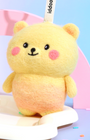 Front view of cute yellow needle-felted bear bag charm with a gradient orange belly, pink cheeks, and a white branded Woobbi tag.