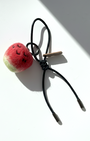Hanging view of needle-felted wool apple keychain with black leather cord, featuring a hand-stitched happy smiley face.
