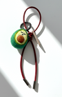 Miniature needle-felted avocado plush charm with dark red burgundy leather cord.