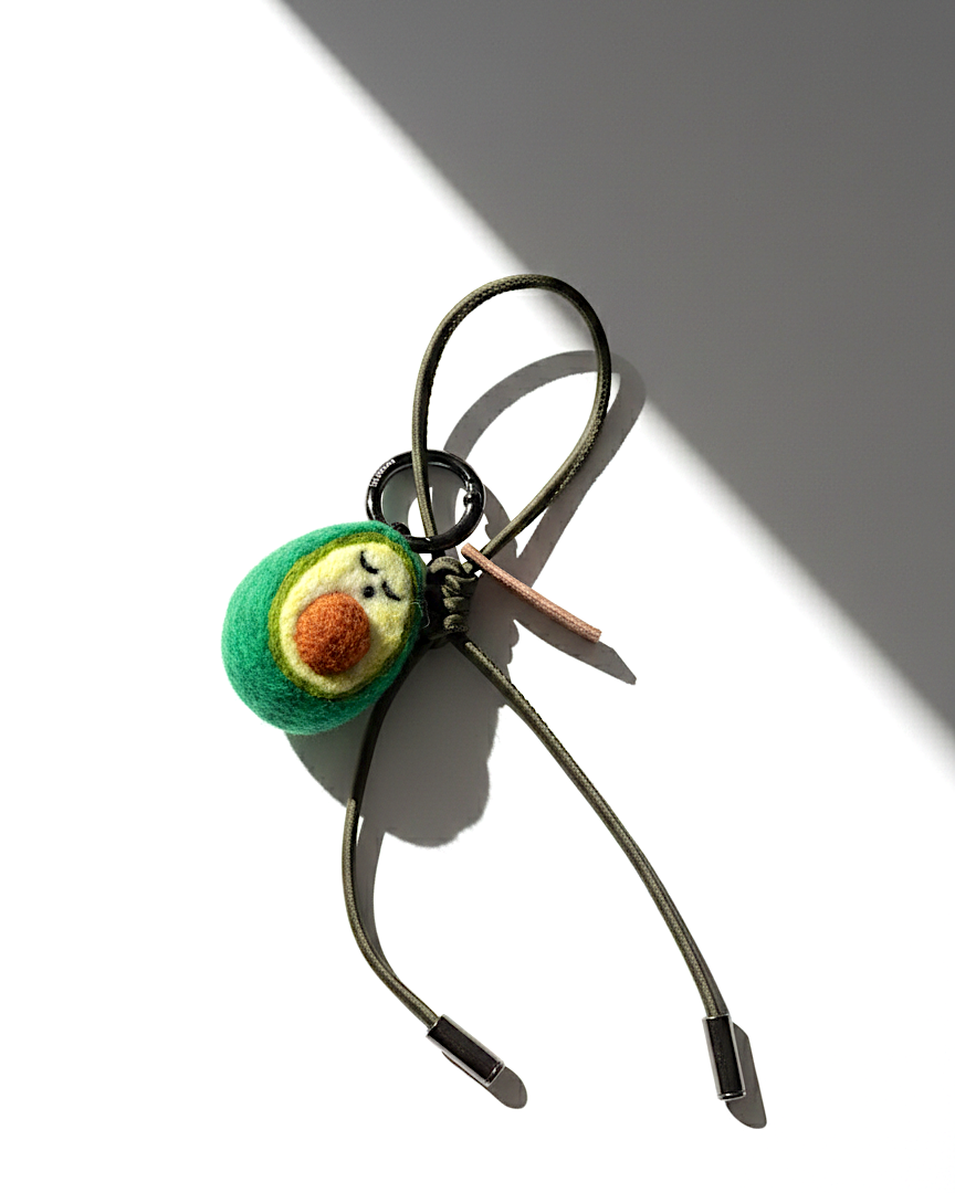 Handmade needle-felted avocado bag charm with olive green cord and silver aglets.