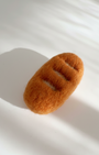 Handmade baguette wool magnet, needle-felted with warm golden texture