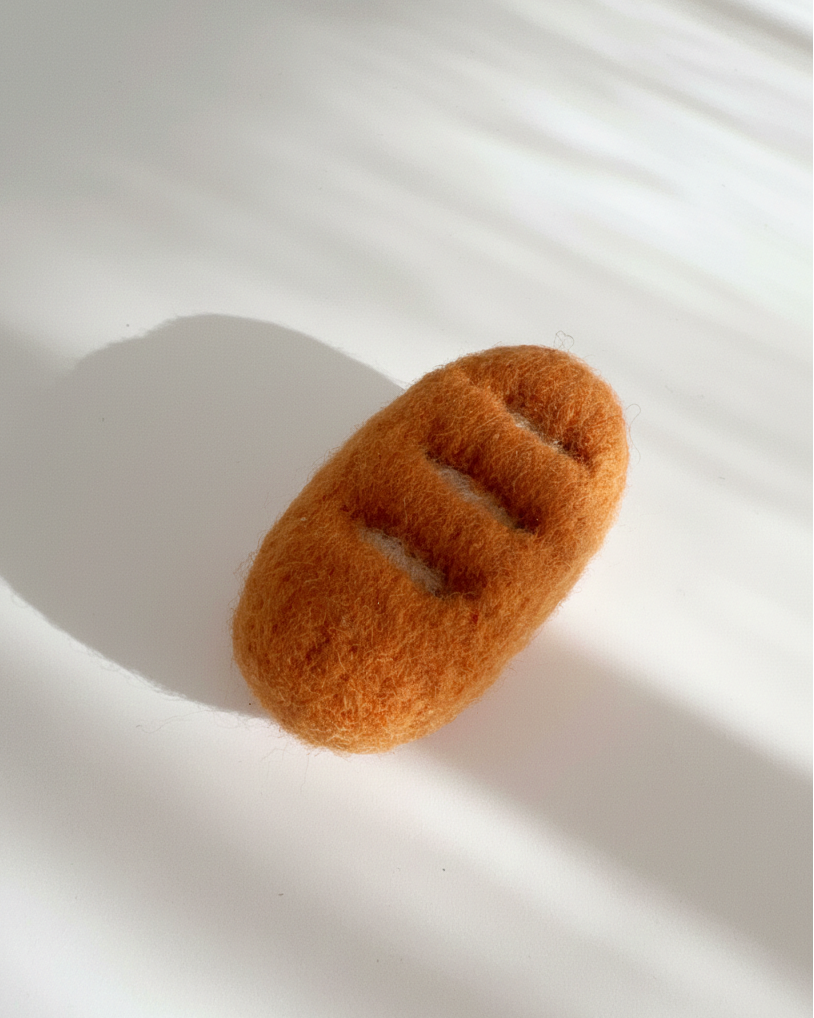 Handmade baguette wool magnet, needle-felted with warm golden texture