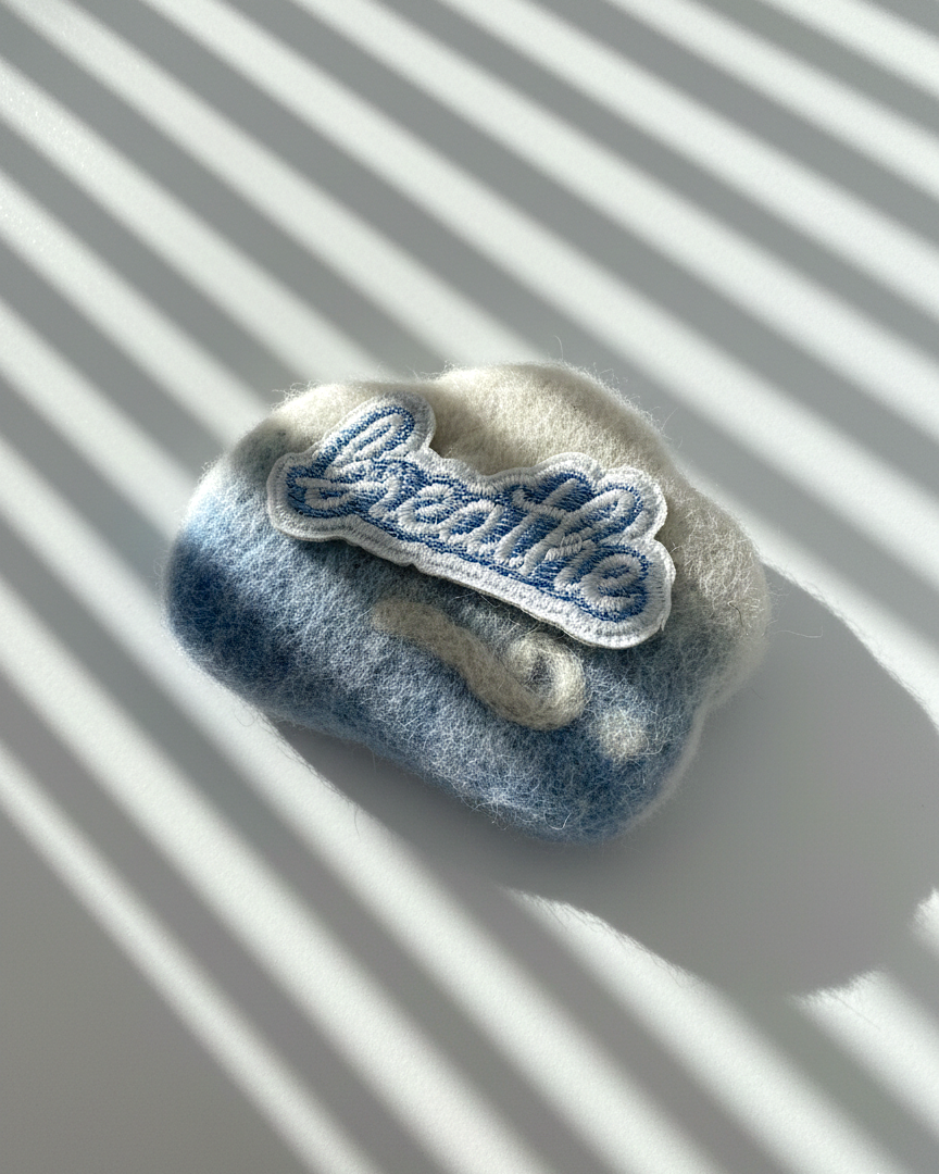 Blue and ivory needle-felted wool fridge magnet featuring Breathe embroidery patch, minimalist handmade decor
