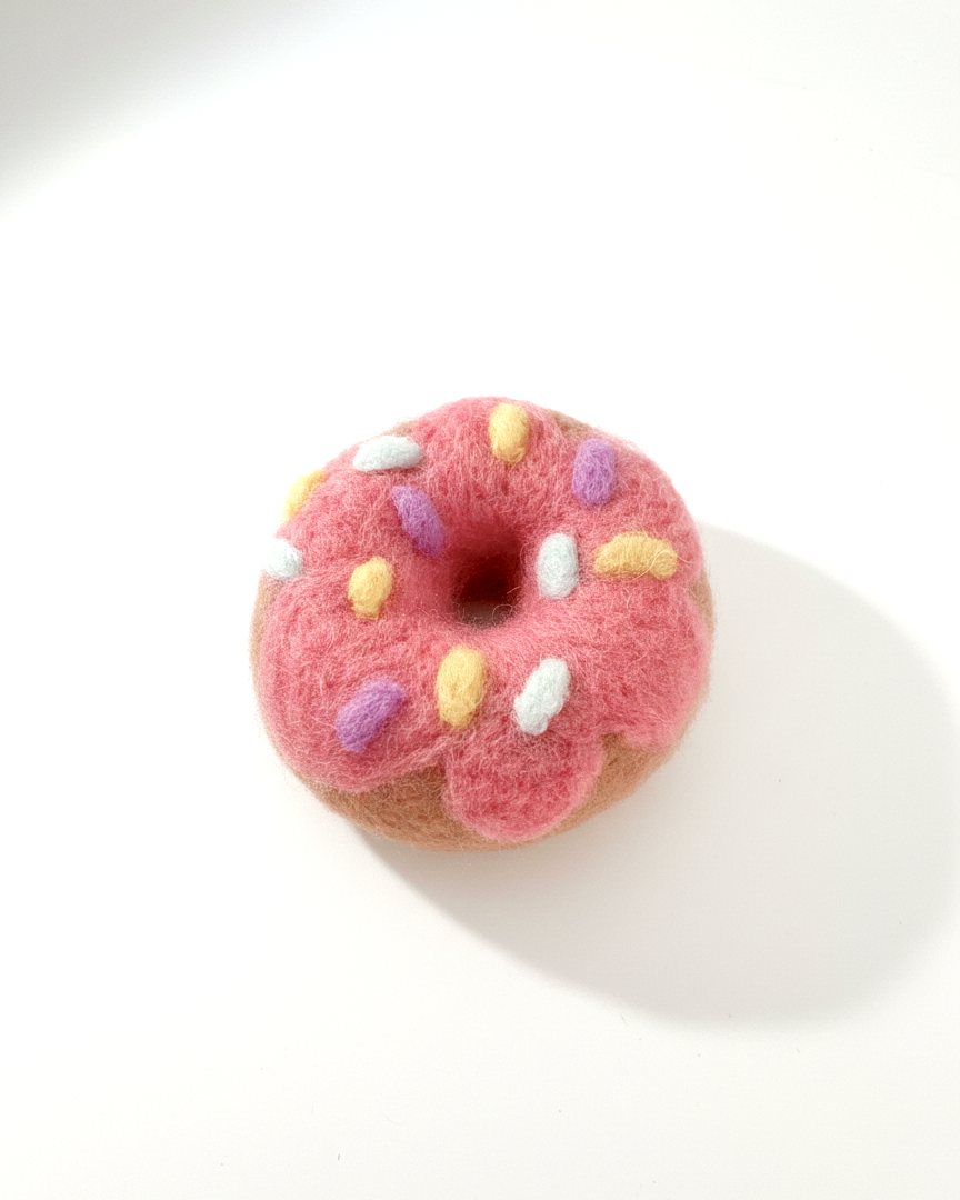 Handmade pink frosted donut wool magnet, needle-felted with colorful sprinkle details