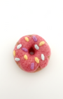 Needle-felted donut magnet made from natural wool, pink frosting with pastel sprinkles