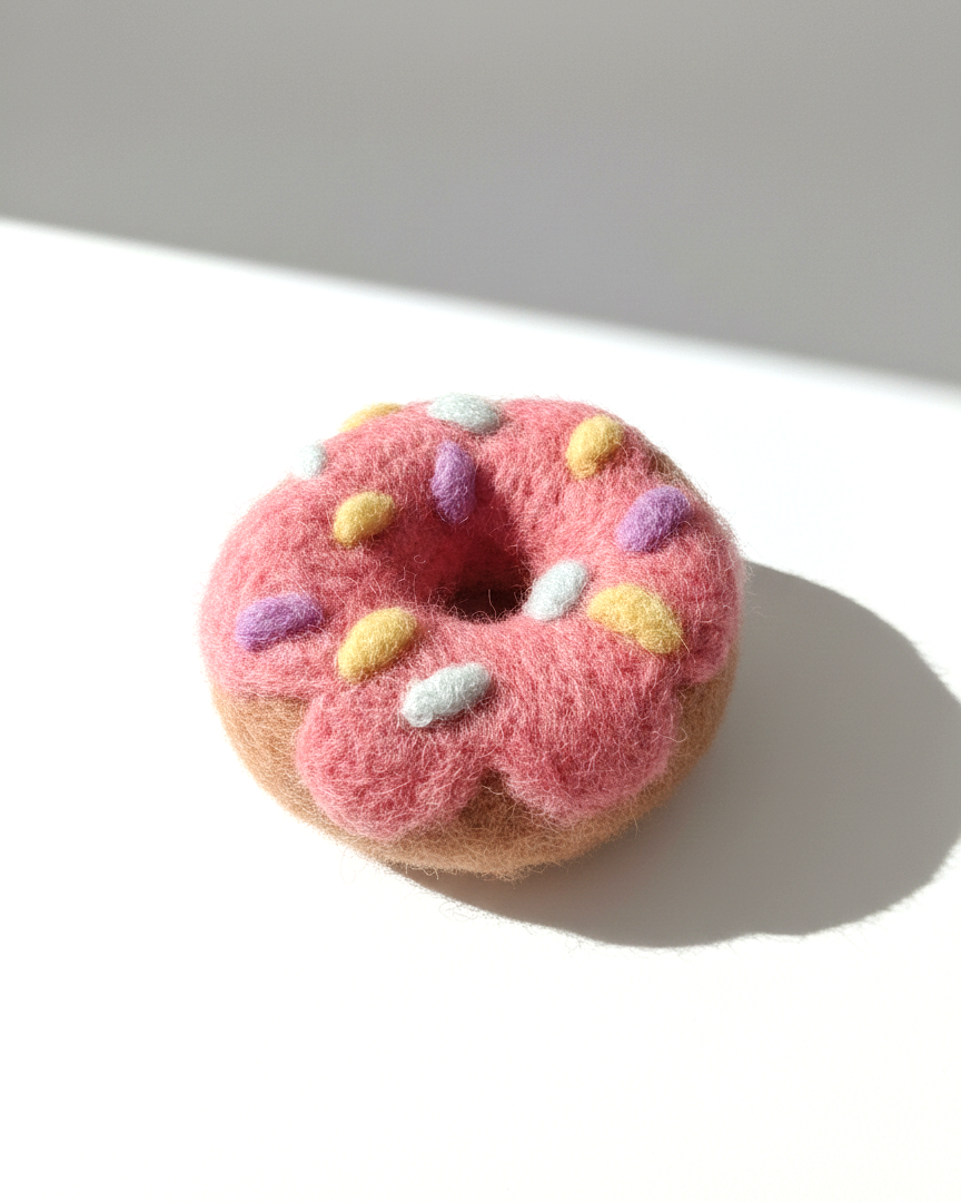 Handcrafted wool donut magnet inspired by a pink frosted donut, minimalist decor