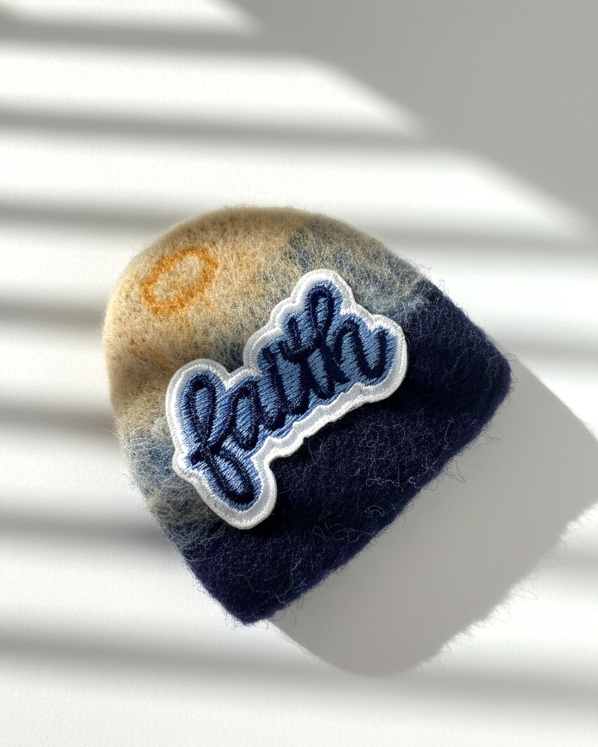Navy blue needle-felted wool magnet with stitched Faith patch, soft rounded handmade fridge decor