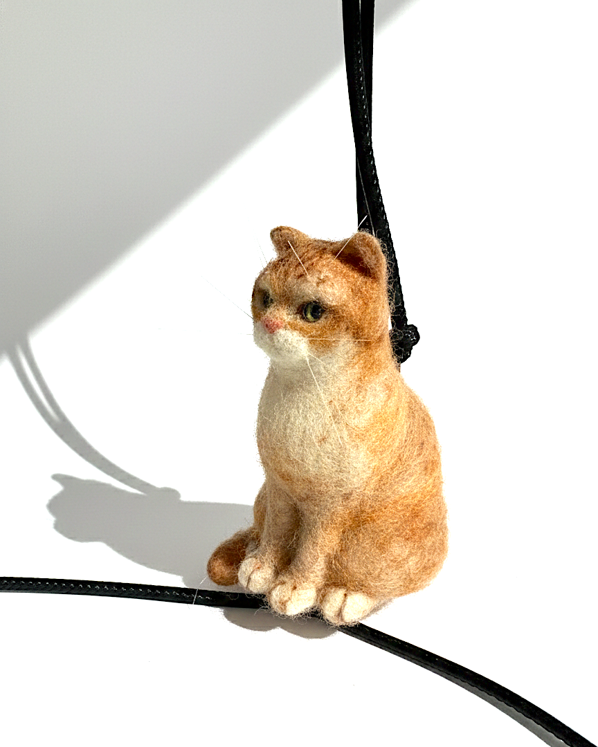 Handmade realistic ginger wool cat sculpture charm in sitting pose, right side view, needle-felted with lifelike details