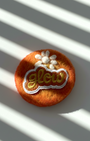 Handmade orange wool fridge magnet with embroidered Glow patch and white flower detail, needle-felted merino wool