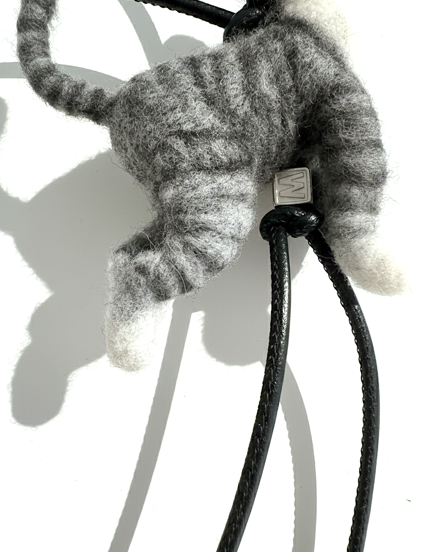 Back view of handmade realistic gray tabby wool cat sculpture charm showing felted fur texture and standing pose