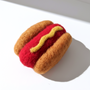 Small handmade wool hot dog magnet with needle-felted bun and sausage detail