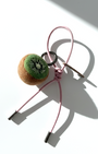 Handmade needle-felted kiwi slice bag charm with a light pink cord and silver hardware.