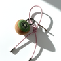 Handmade needle-felted kiwi slice bag charm with a light pink cord and silver hardware.