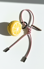 Needle-felted lemon slice bag charm with pink cord and silver aglets.