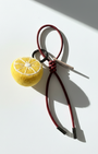Miniature needle-felted lemon slice keychain with dark red burgundy cord.