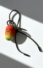 Cute needle-felted mango smiley face plush charm with olive green cord.