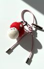 Handmade needle-felted red mushroom bag charm with a light pink cord and silver aglets.