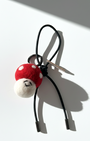 Miniature needle-felted mushroom plush charm with a black leather cord and silver hardware.