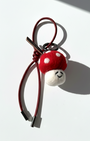 Cute red and white spotted mushroom felt charm with a dark red burgundy cord.