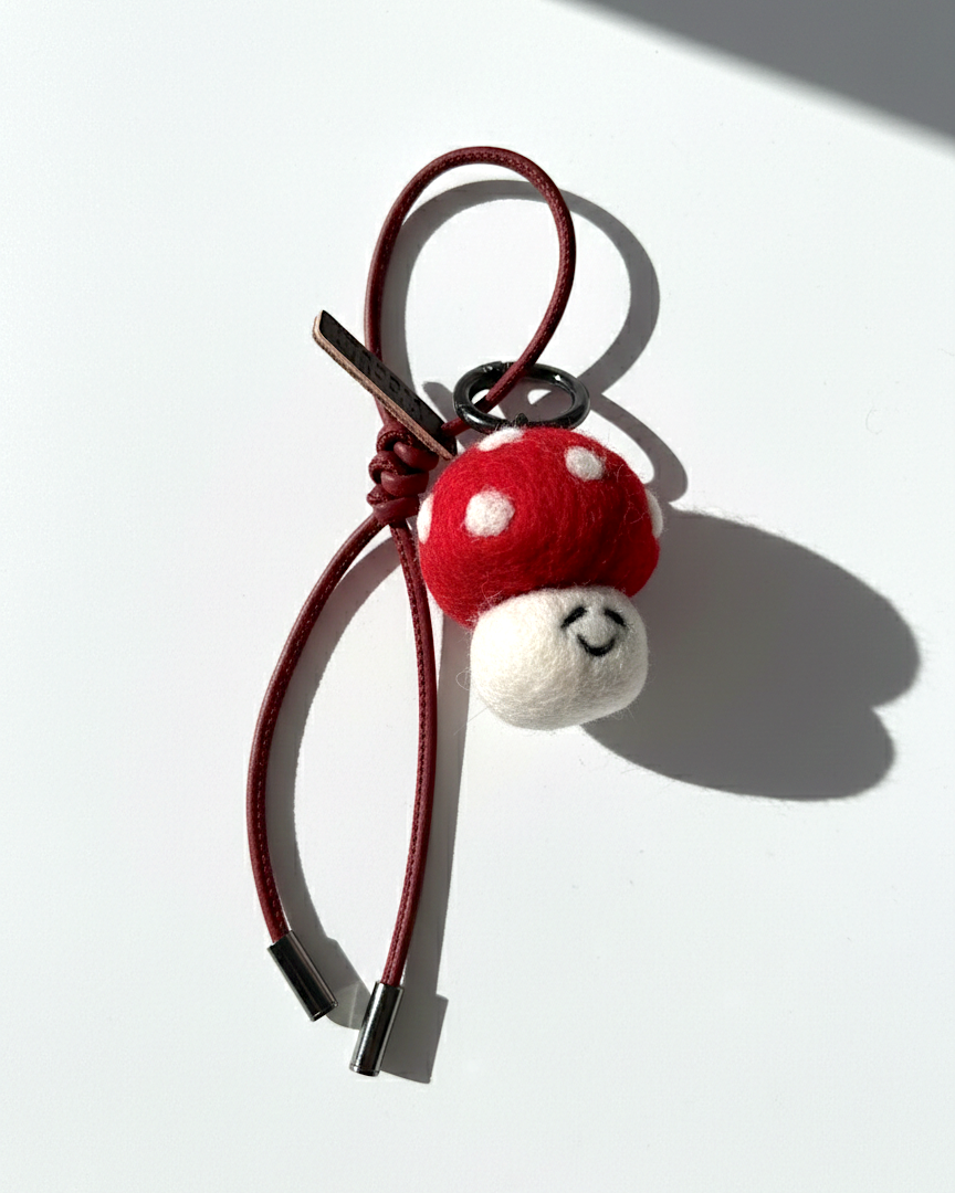 Cute red and white spotted mushroom felt charm with a dark red burgundy cord.