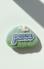 Handmade green wool fridge magnet with embroidered Peace patch and cloud detail, needle-felted merino wool
