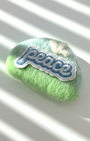 Mint green needle-felted wool magnet with stitched Peace patch, soft rounded handmade fridge decor