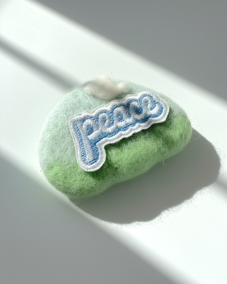 Minimalist green wool fridge magnet with Peace patch and white cloud accent, handmade felt home decor