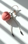 Handcrafted wool felt strawberry bag charm back view with cream leather loop strap, realistic needle felt fruit keychain on minimalist white background
