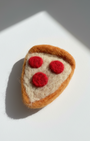 Close-up of handmade wool pepperoni pizza slice fridge magnet showing felt texture and rounded edges