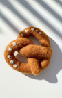 Handcrafted wool pretzel magnet featuring twisted design and subtle salt details