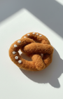 Small handmade pretzel wool magnet with soft felted texture