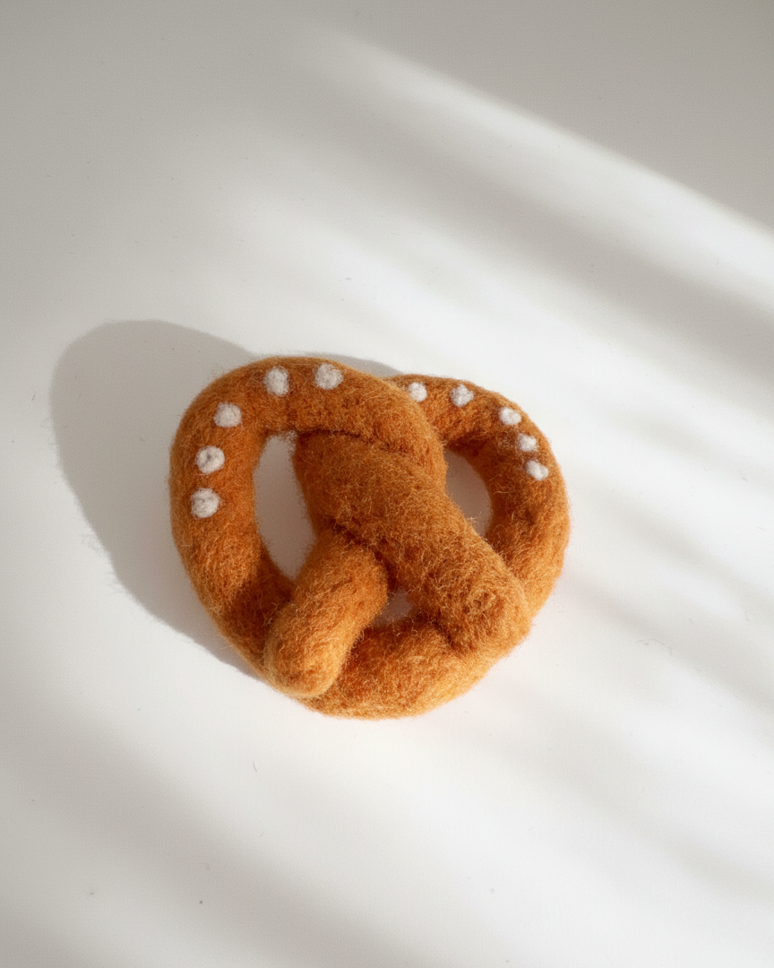 Artisan needle-felted pretzel magnet inspired by a traditional soft pretzel