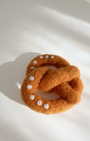 Natural wool pretzel magnet handmade with dense needle-felted construction