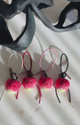 Panning video showing the full collection of needle-felted apple bag charms with four leather strap options: white, black, red, and pink, arranged on a marble surface.