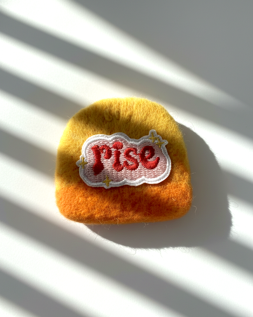 Minimalist yellow wool fridge magnet with Rise patch and star accents, handmade needle-felted home decor