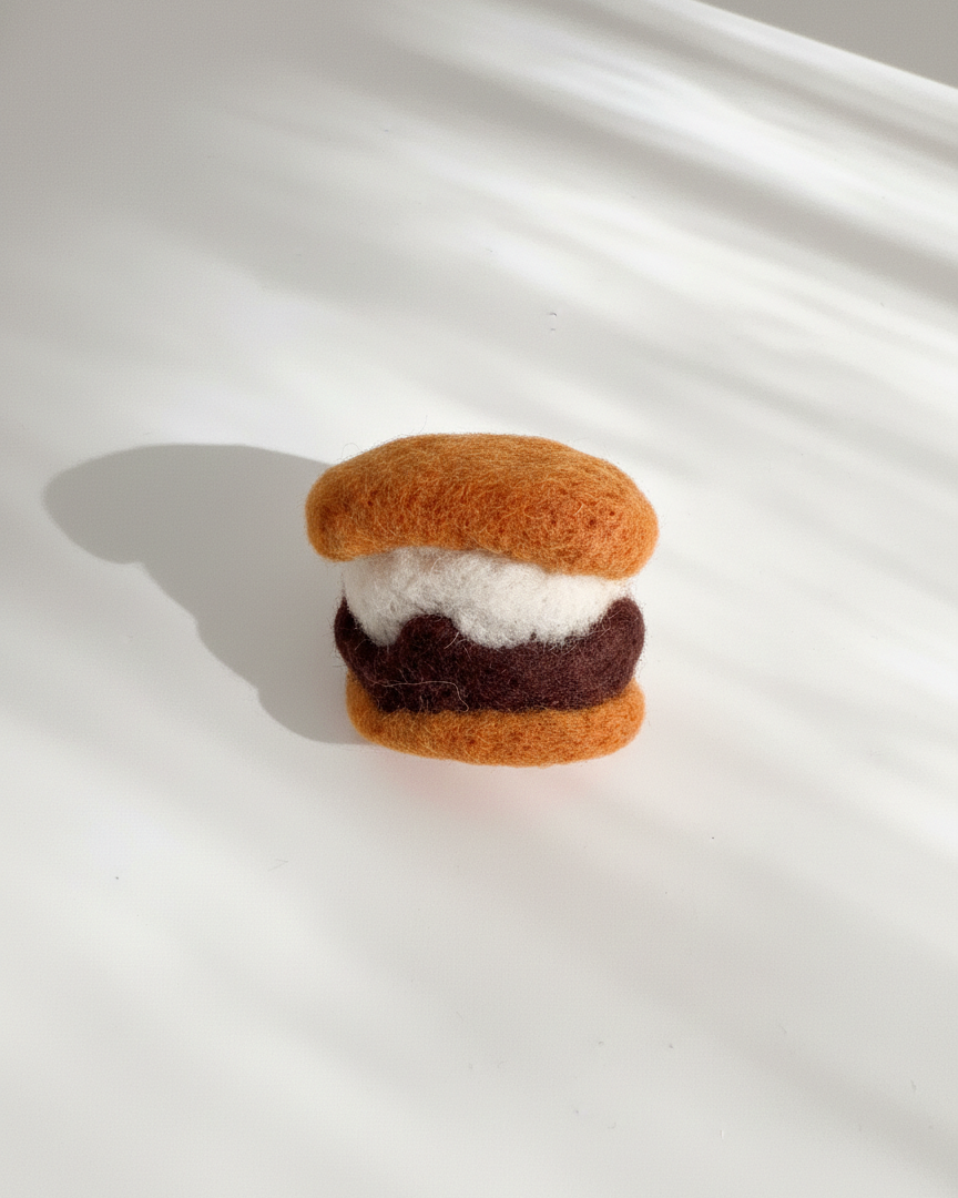 Small handmade s’more wool magnet featuring marshmallow and chocolate filling