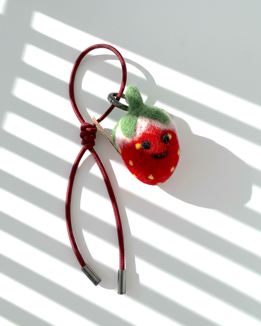 Wool felt strawberry bag charm with red leather loop, handcrafted fruit keychain accessory