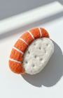 Close-up of handcrafted wool sushi magnet, needle felted salmon sushi with detailed wool texture